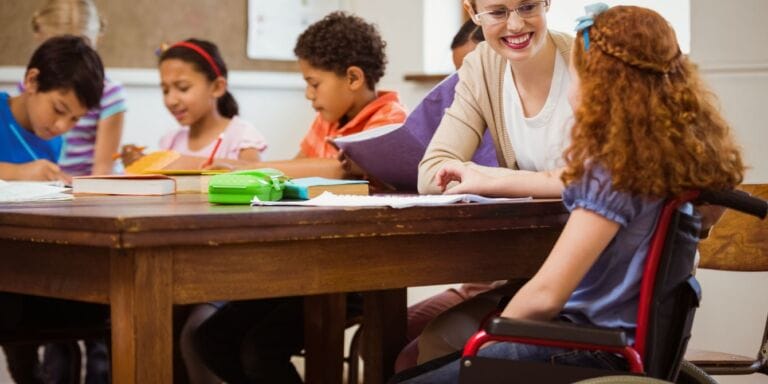 my daughter's first day of school- teacher helping student in wheelchair