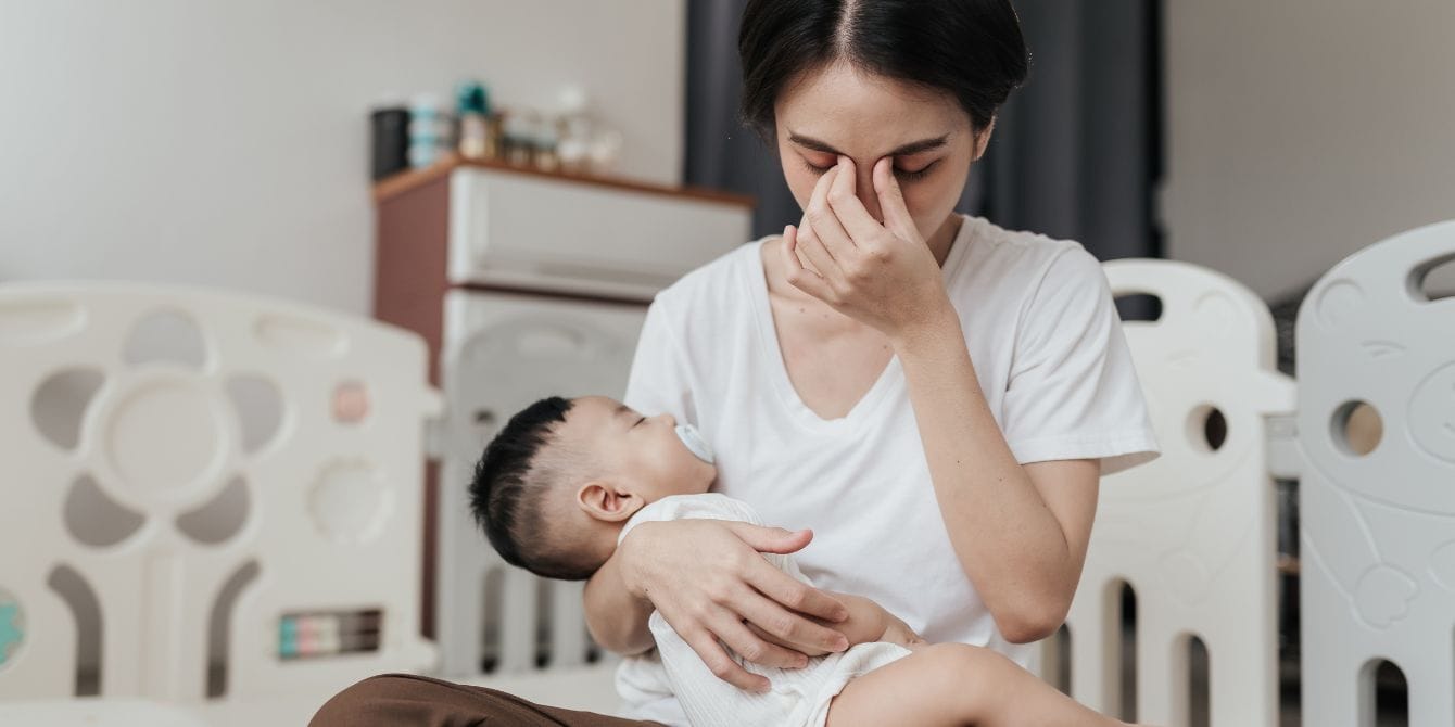 maternal exhaustion - tired mom holding sleeping baby