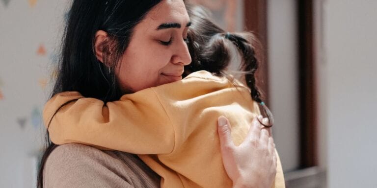 mom hugging child looking content parent mental health Motherly