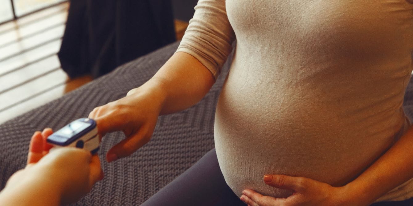 pregnant woman at doctor office - questions to ask in third trimester appointments - Motherly