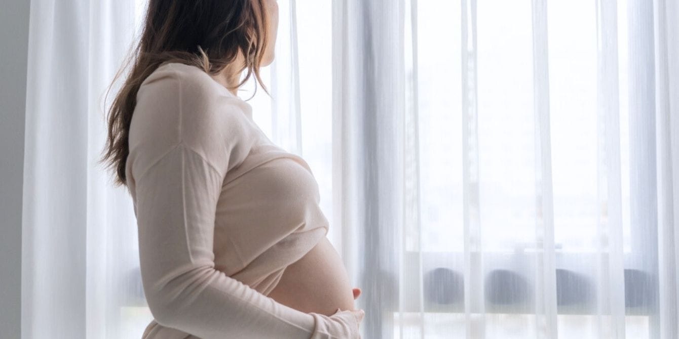 Pregnant woman looking out window