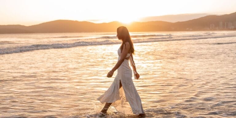 woman walking at beach sunset - gratitude trap